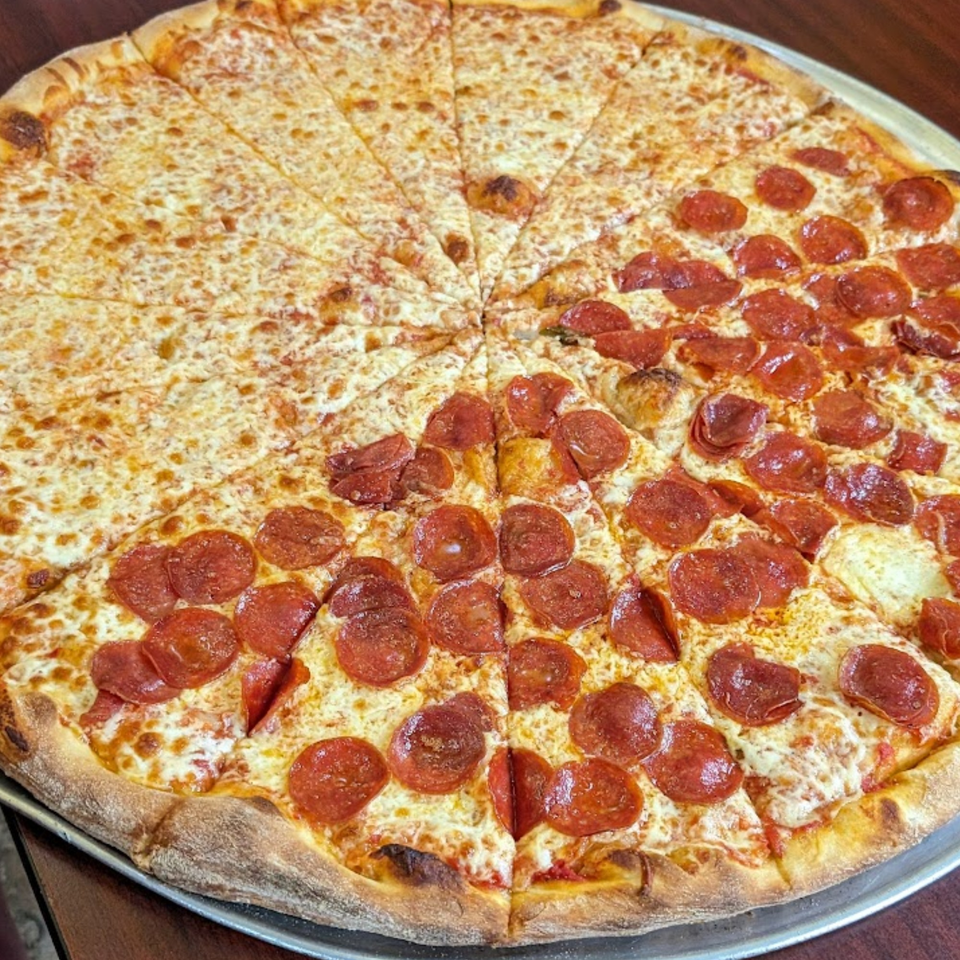 A large pizza from Sal's Pizzeria, half cheese and half pepperoni, on a metal tray.